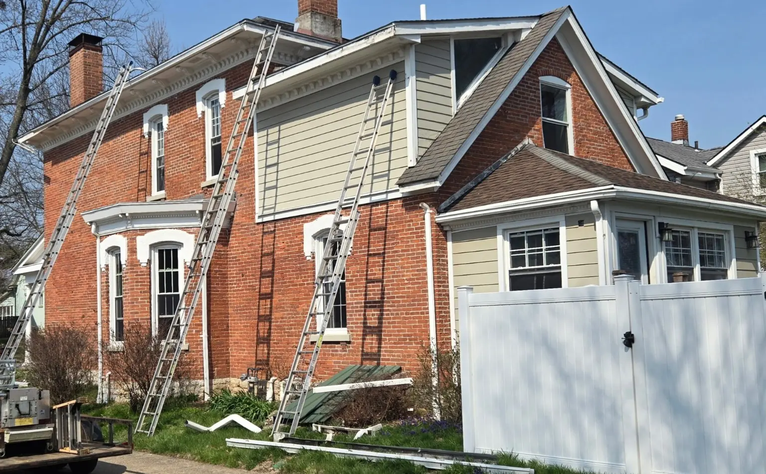 Ladders and removed gutter sections during a CleanFlow seamless gutter replacement project